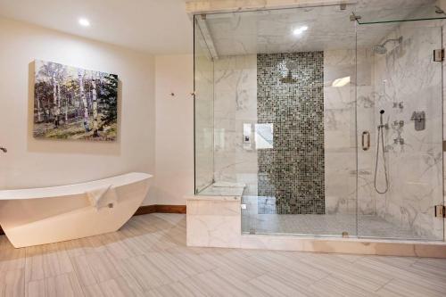 比弗河Beaver Creek Lodge 510的带浴缸和玻璃淋浴间的浴室。