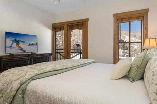 比弗河Villa Montane #212的一间卧室设有一张床、一台电视和窗户。