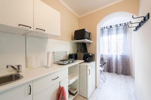 布达佩斯Barbarosa Sweet Dream 3的厨房配有白色橱柜和窗户。