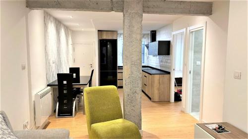 毕尔巴鄂Bonito Apartamento en Zamakola的一间带绿色椅子的客厅和一间厨房