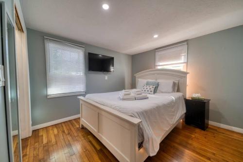 巴恩斯特布尔Comfortable 2 Bedroom Gateway nearby Downtown的卧室配有白色的床,墙上配有电视