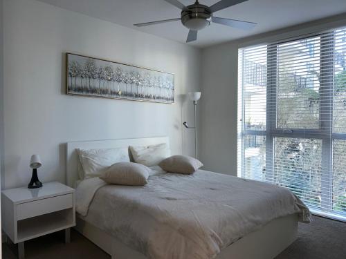 洛杉矶LUXURY APARTMENT IN HOLLYWOOD的白色卧室配有床和吊扇