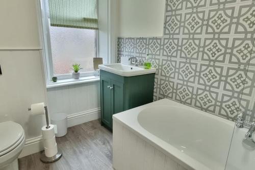 Burley in WharfedaleDale Cottage Cozy 3 Bedroom nr Ilkley - West Yorkshire的一间带水槽和卫生间的浴室以及窗户。