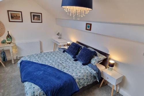 Burley in WharfedaleDale Cottage Cozy 3 Bedroom nr Ilkley - West Yorkshire的一间卧室配有蓝色的床、蓝色床单和枕头