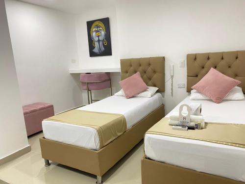 卡塔赫纳Hotel Hernández CTG的一间卧室配有两张床和一张桌子