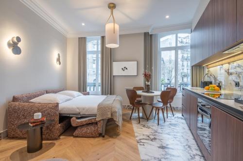 巴黎Yuna Saint-Germain-des-Prés - Serviced Apartments的一间卧室配有一张床,厨房配有桌子