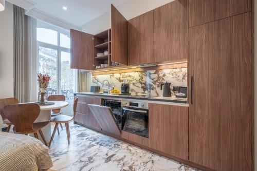 巴黎Yuna Saint-Germain-des-Prés - Serviced Apartments的一间带木制橱柜的厨房和一间用餐室