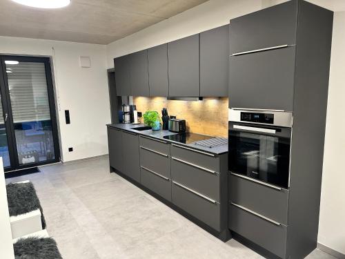 明斯特Luxuriöses Apartment direkt am Kanal 125 m² - youpartments的厨房配有黑色橱柜和炉灶烤箱。
