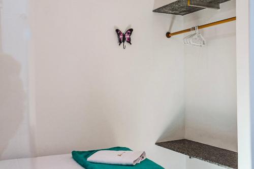阿拉亚尔达茹达Residencial Ilha do Sol的白色的房间,墙上挂着蝴蝶