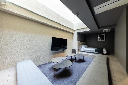 东京2269AZAVU的客房设有1张床、2张桌子和1台电视。