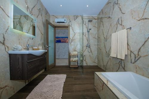 梅利哈Clifftop Modern Apartment的浴室配有盥洗盆和浴缸。