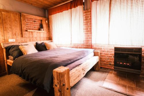 贝内茨科Little Trees Apartment的一间卧室设有一张带壁炉和窗户的床。