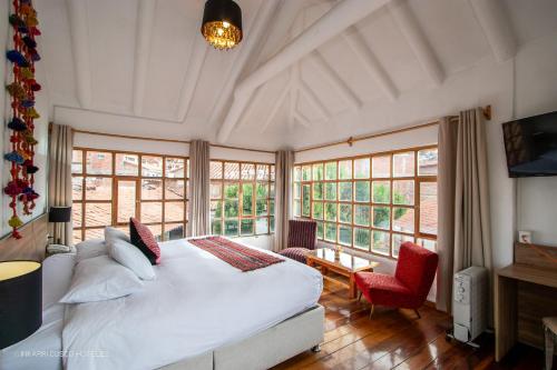 库斯科Inkarri Cusco的卧室设有白色大床和窗户。