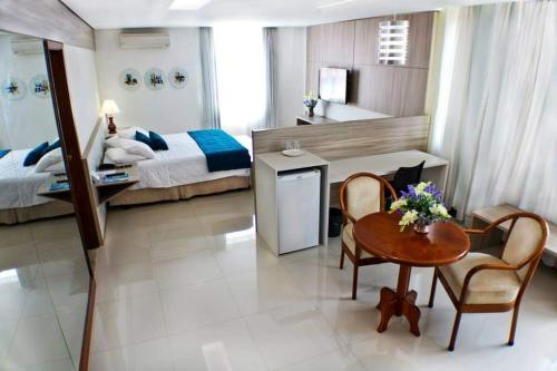 因佩拉特里斯Posseidon Hotel的卧室配有一张床和一张桌子及椅子