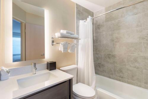 格伦维尤Best Western Glenview - Chicagoland Inn and Suites的一间带水槽、卫生间和镜子的浴室