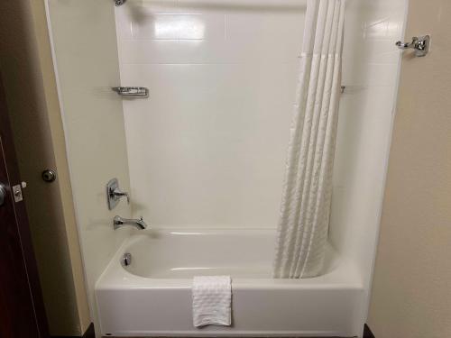阿斯托里亚哥伦比亚河康福特套房酒店的浴室内设有带浴帘的白色浴缸
