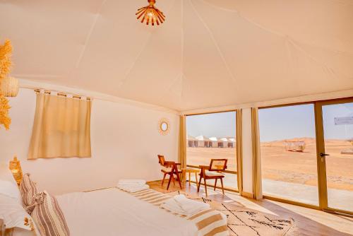 梅尔祖卡Sahara Royal Resort的卧室配有一张床和一张桌子及椅子