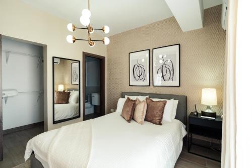 圣多明各Luxury 2Bedr, 2 Balcony Pool, Gym, Downtown Santo Domingo的卧室配有白色的床和镜子