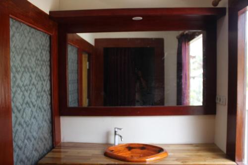 吉利特拉旺安Gili Tempoe的一间带木制水槽和镜子的浴室
