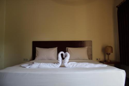 吉利特拉旺安Gili Tempoe的两只天鹅用毛巾铺在床上