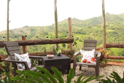 拉维加cabañas tamborillo的庭院设有两把椅子和一张桌子,享有美景。