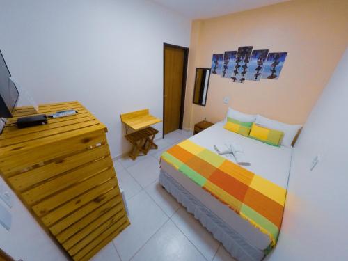 马拉戈日Barra Grande Pousada的一间卧室配有一张床和一个带电视的梳妆台