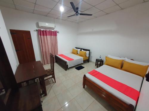 维勒珀图Wilpattu homestay by Ceylon group的一间卧室配有两张床、一张桌子和一张桌子