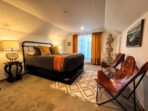 西塞德Sea Glass Inn的一间卧室,卧室内配有一张床和椅子