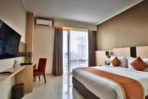 日惹Riss Hotel Malioboro的酒店客房设有一张床和一个大窗户