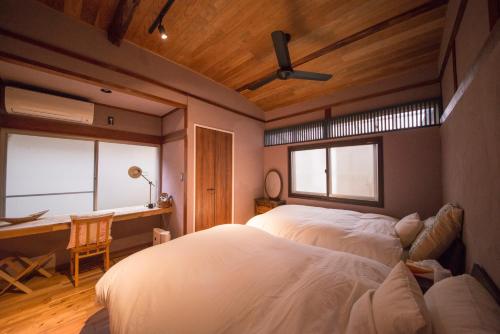 雾岛市はなれ奏HanareSou-天然温泉付き貸別荘-1棟貸し的一间卧室配有一张床、一张书桌和一个窗户。