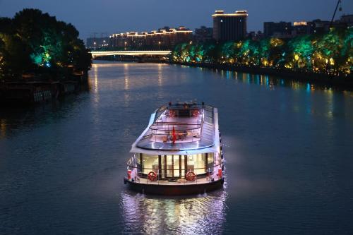 杭州杭州运河祈利酒店(非物质文化遗产酒店）的夜间沿河航行的船只
