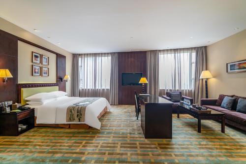 惠州惠阳丽景国际花园酒店的酒店客房,配有床和沙发