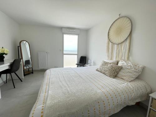 圣布里文莱丝皮恩Appartement Saint-Brevin-les-Pins, 2 pièces, 3 personnes - FR-1-364-140的卧室配有一张壁挂镜子的床