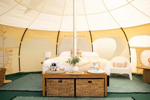 Foxton BeachFoxton Beach Holiday Park的帐篷内的一张床位,前面配有桌子