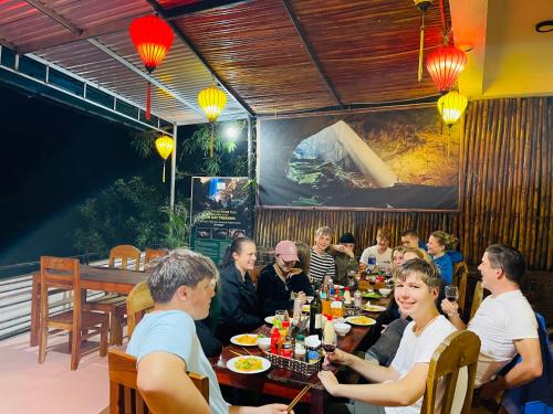 峰牙Phong Nha Coco Riverside的一群坐在餐厅桌子上的人