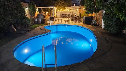 门多萨Hotel Namaste的夜间大型蓝色游泳池