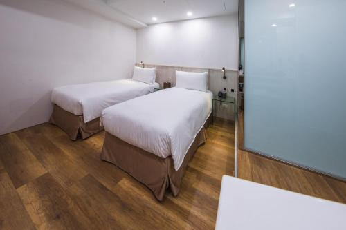 台北雅璞文旅的小型客房的两张床,配有镜子