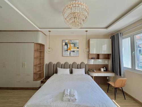 胡志明市Amazing Merit Ben Thanh的一间卧室配有一张大床和一个吊灯。