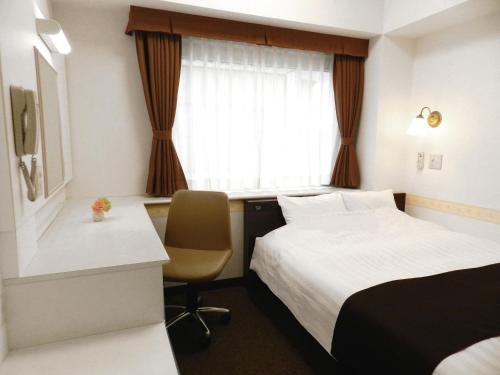 东京新桥登记入住酒店的配有一张床、一张书桌和一扇窗户的酒店客房