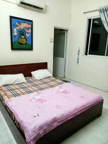 头顿Nhà nghỉ MINH HOÀNG的一间卧室配有一张带粉色毯子的大床