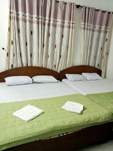 头顿Nhà nghỉ MINH HOÀNG的一间卧室配有两张带毛巾的床