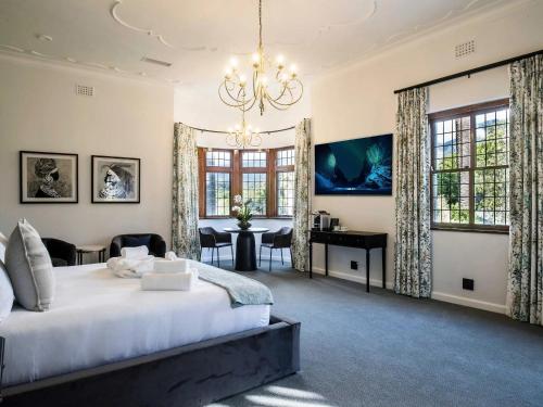 开普敦Palm House Boutique Hotel的一间卧室配有一张大床和一个吊灯。