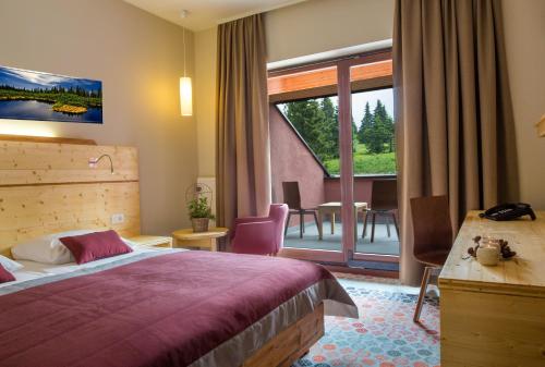 兹雷切Hotel Natura的酒店客房设有一张床和一个阳台。