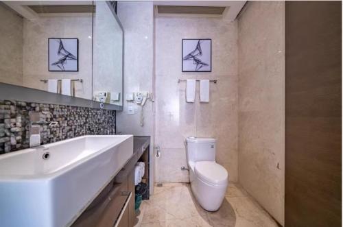 广州米莱尼亚行政公寓（广州火车东站珠江新城店）的白色的浴室设有水槽和卫生间。