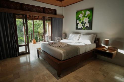 乌布New Mumbul Ubud的一间带大床的卧室和一个阳台
