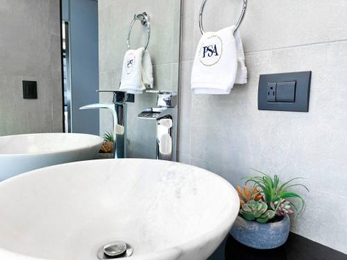 瓜亚基尔Puerto Santa Ana Luxury Suites Guayaquil的浴室设有白色水槽和2条白色毛巾。