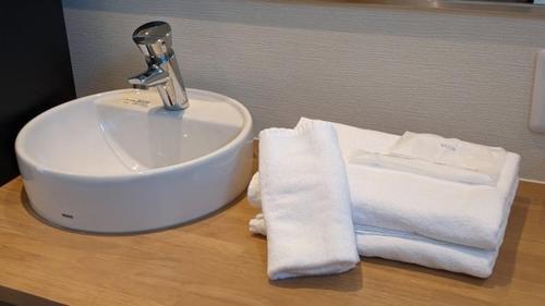 和歌山関空国際ホテル的浴室水槽和木制台面上的毛巾
