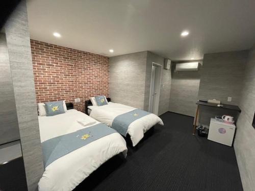 和歌山関空国際ホテル的一间设有两张床和砖墙的房间
