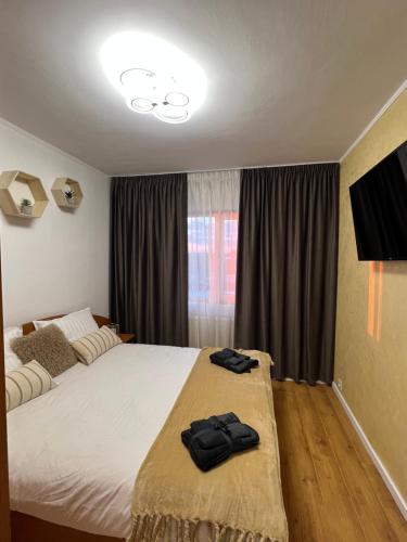 GiurgiuBest Rent Apartments的一间卧室配有一张带两张黑色毛巾的床