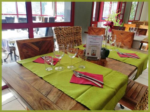 里摩日Hôtel du Parc Limoges & Restaurant "Le temps d'une pause"的一张带绿桌布和酒杯的木桌